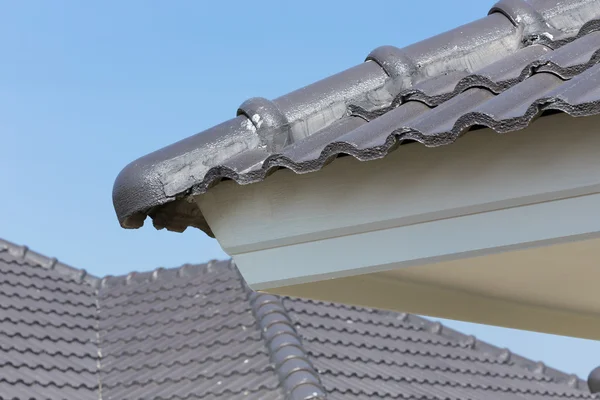 Schwarze Dachziegel auf Haus mit blauem Himmel — Stockfoto