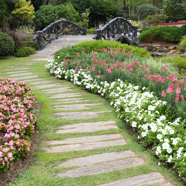 Landscape of floral gardening with pathway and bridge in garden — Stock Photo, Image