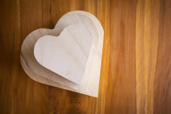 Caja de madera en forma de corazón sobre fondo de madera marrón —  Fotos de Stock