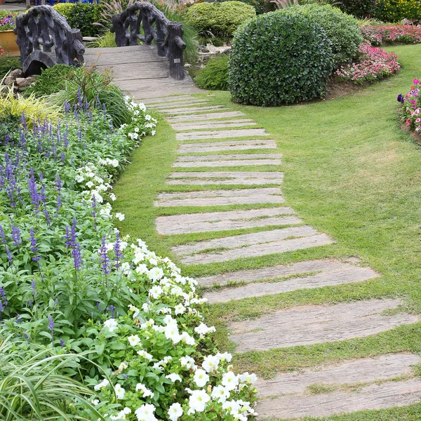 Landskap av blommig trädgårdsarbete med väg och bro i trädgården — Stockfoto