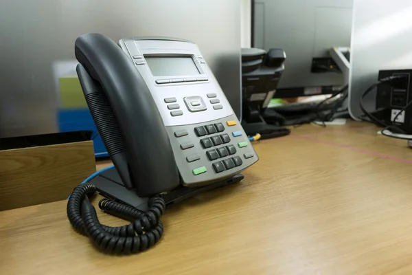 Teléfono negro sobre mesa trabajo de oficina —  Fotos de Stock