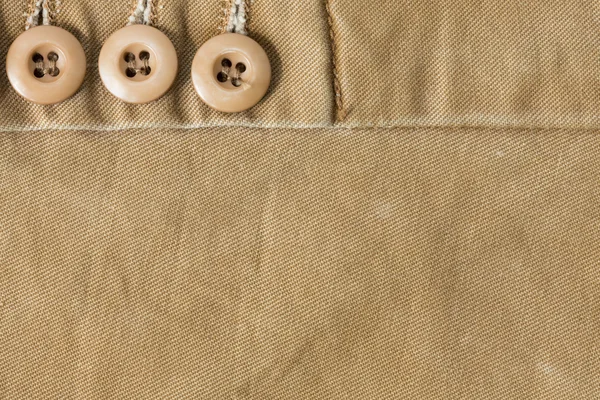 Design botton of brown shirt on fabric textile background — Stock Photo, Image