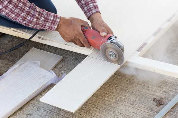 Tischler greift auf Baustelle mit Elektrosäge auf Holz — Stockfoto