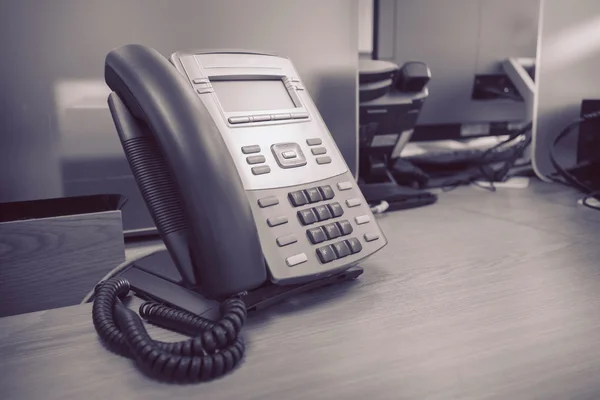 Teléfono negro sobre mesa trabajo de oficina —  Fotos de Stock