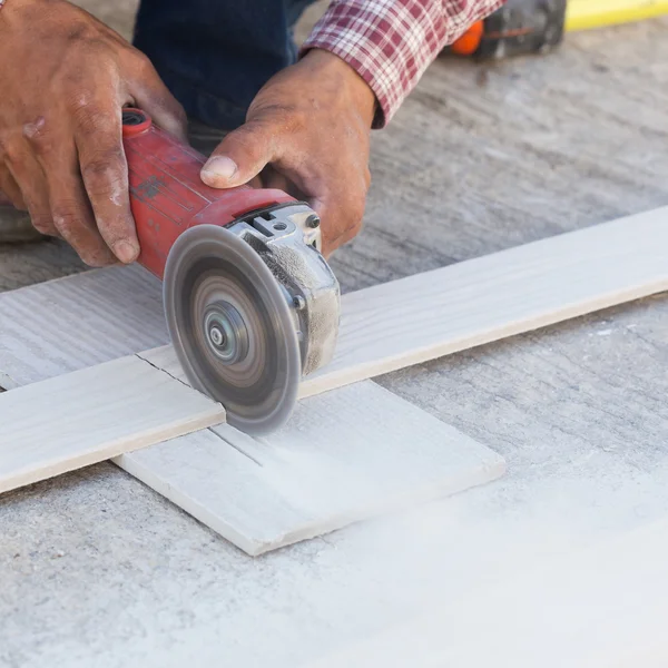 Timmerman handen met behulp van elektrische zag op hout op de bouwplaats — Stockfoto