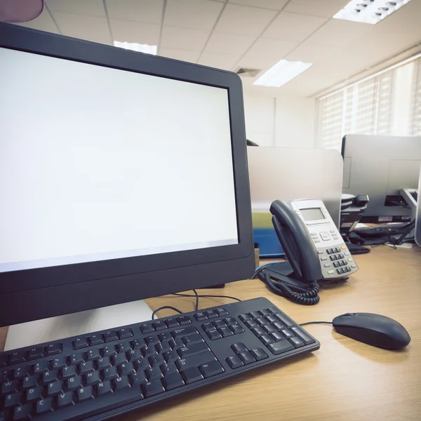 Mesa de trabajo en la oficina con el teléfono y el ordenador PC — Foto de Stock