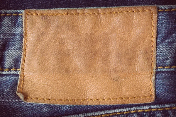 Etichetta in pelle marrone su blue jeans — Foto Stock