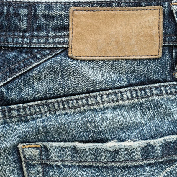 Jeans byxor med tillbaka pocket och brunt läder tag — Stockfoto