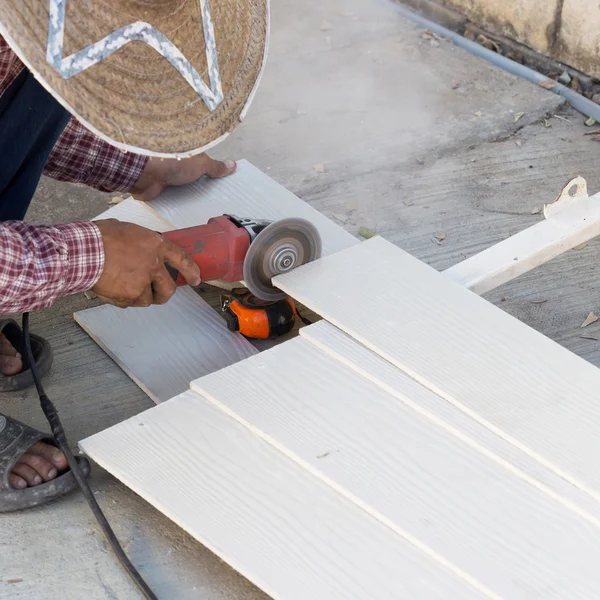 Snickare händer med elektriska såg på trä på byggarbetsplats — Stockfoto