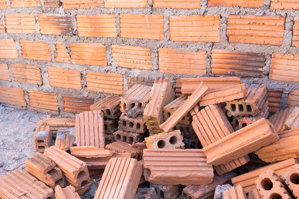 Stapel stenen in bouwplaats met bakstenen muur achtergrond — Stockfoto