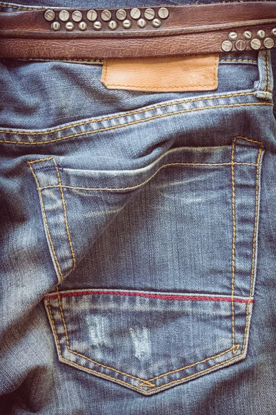 Mavi kot pantolon deri kemer ve etiket etiketi ile — Stok fotoğraf