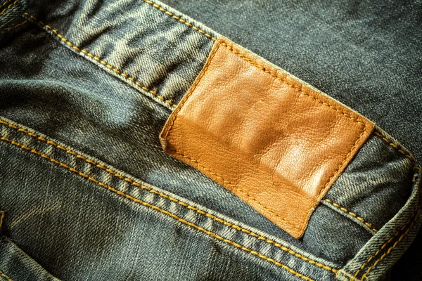 Brown leather tag on black jeans — Stock Photo, Image