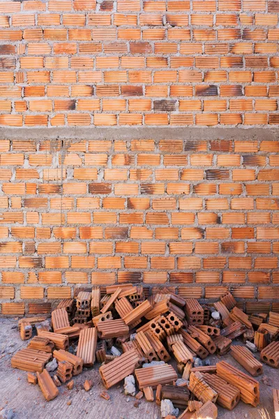 Hög med tegelstenar i byggarbetsplatsen med tegel vägg bakgrund — Stockfoto