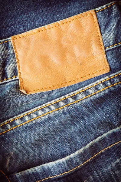 Brunt läder tag på Blå jeans — Stockfoto