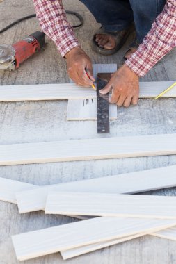 marangoz ahşap bir gemide işaretleme bir çizgi çizmek için cetvel kullanarak
