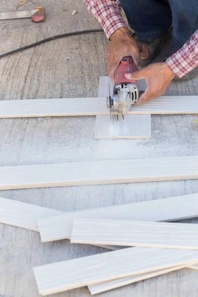 Carpenter hands using electric saw on wood at construction site — Stock Photo, Image