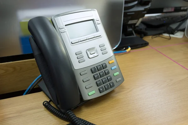 Teléfono negro sobre mesa trabajo de oficina —  Fotos de Stock