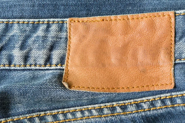 Étiquette en cuir marron sur jeans bleus — Photo