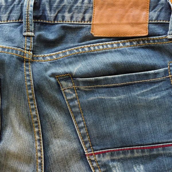 Blue jeans with back pocket and brown leather tag — Stock Photo, Image