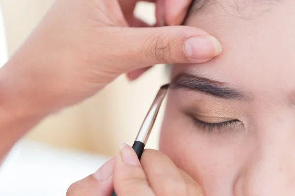 Maquillage beauté avec brosse sourcil sur jolie femme — Photo