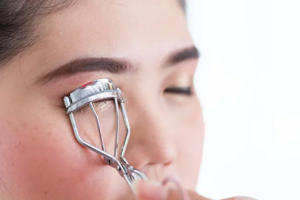 Trucco artista utilizzando bigodino ciglia sul viso della donna — Foto Stock