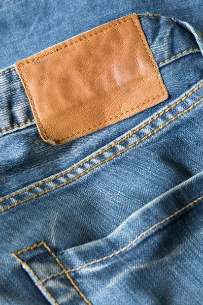 Brown leather tag on blue jeans — Stock Photo, Image