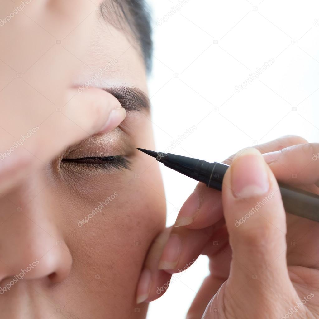 makeup beauty with brush eye liner on pretty woman