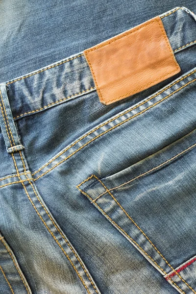 Blue jeans with back pocket and brown leather tag — Stock Photo, Image