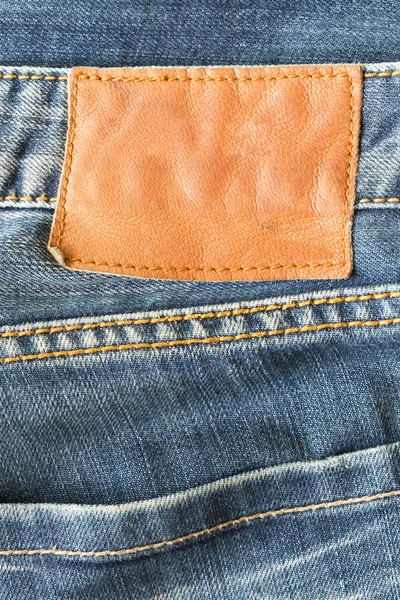 Étiquette en cuir marron sur jeans bleus — Photo