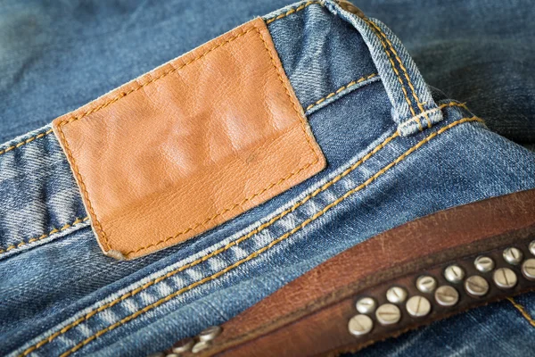 Blå jeans med läder bälte och etikett tag — Stockfoto