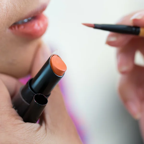 Оранжевая помада для макияжа с косметикой для женщин — стоковое фото