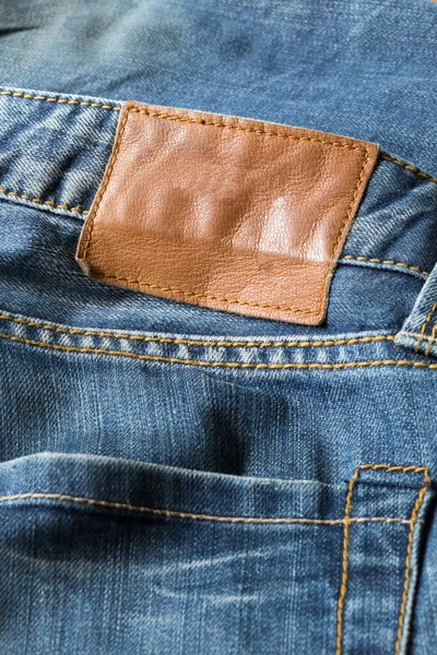 Étiquette en cuir marron sur jeans bleus — Photo
