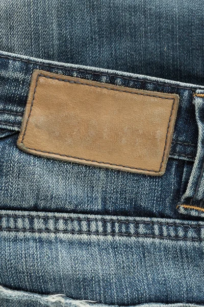 Étiquette en cuir marron sur jeans bleus — Photo