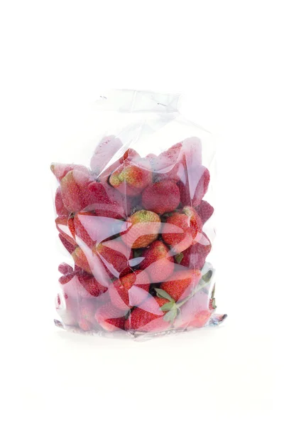 Fruta jugosa de fresa en el embalaje de la bolsa de plástico aislado —  Fotos de Stock