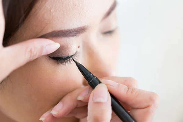 Maquillaje belleza con cepillo delineador de ojos en cara de mujer bonita — Foto de Stock