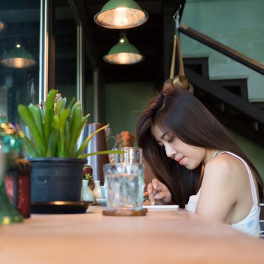 Cafe kahve dükkanında bir cep telefonu kullanarak kadın yaşam tarzı