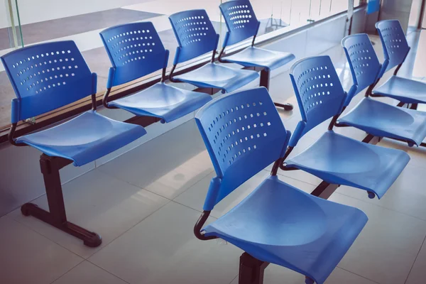 Customer waiting area with rows of blue seats in office — Stock Photo, Image