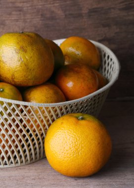 ahşap masa arka plan üzerinde beyaz sepet içinde turuncu meyve