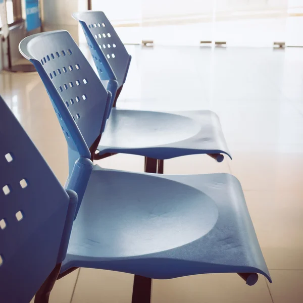 Customer waiting area with rows of blue seats in office — Stock Photo, Image