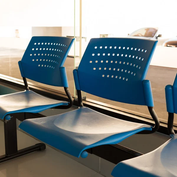 Customer waiting area with rows of blue seats in office — Stock Photo, Image