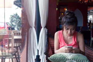 Kadın yaşam tarzı bir cep telefonu Cafe kahve dükkanında kullanılır.