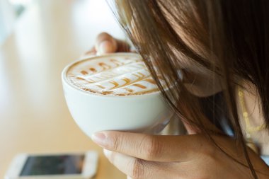 Güzel kız sıcak kahve veya çay kahve kafede içme