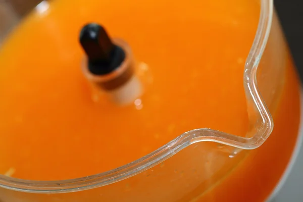 Fresh orange juice in juicer machine with hand — Stock Photo, Image