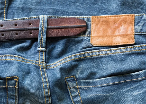 Jeans azules con cinturón de cuero y etiqueta —  Fotos de Stock