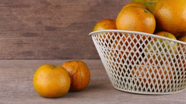 ahşap masa arka plan üzerinde beyaz sepet içinde turuncu meyve