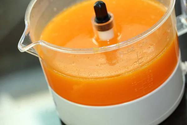 Zumo de naranja fresco en la máquina de juicer con mano — Foto de Stock