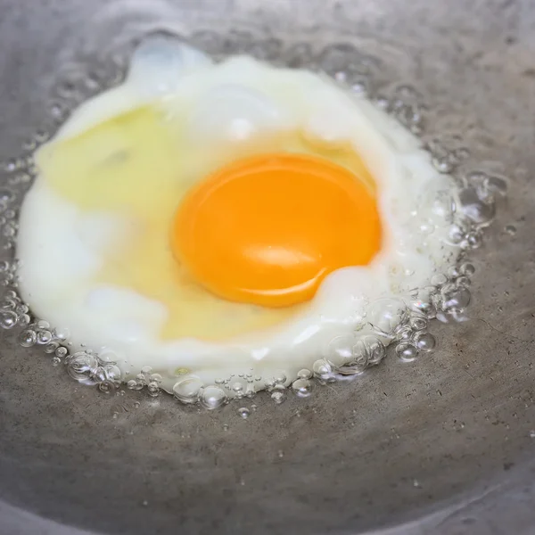 Cocinar huevo frito en sartén caliente con aceite — Foto de Stock