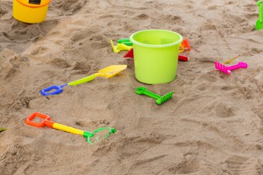 Çocuğun oyuncaklar oynamak için kova kum ve oyun alanında kürek