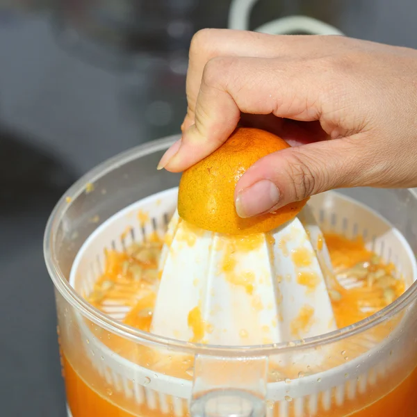 오렌지 과일 과즙 짜는 기구 기계에서 여자 손으로 압착 — 스톡 사진