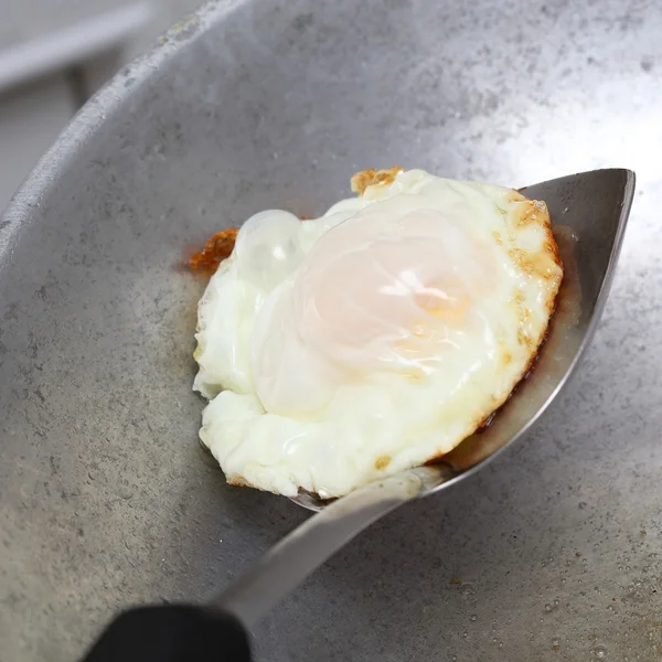 Cooking fried egg in hot pan with oil — Stock Photo, Image